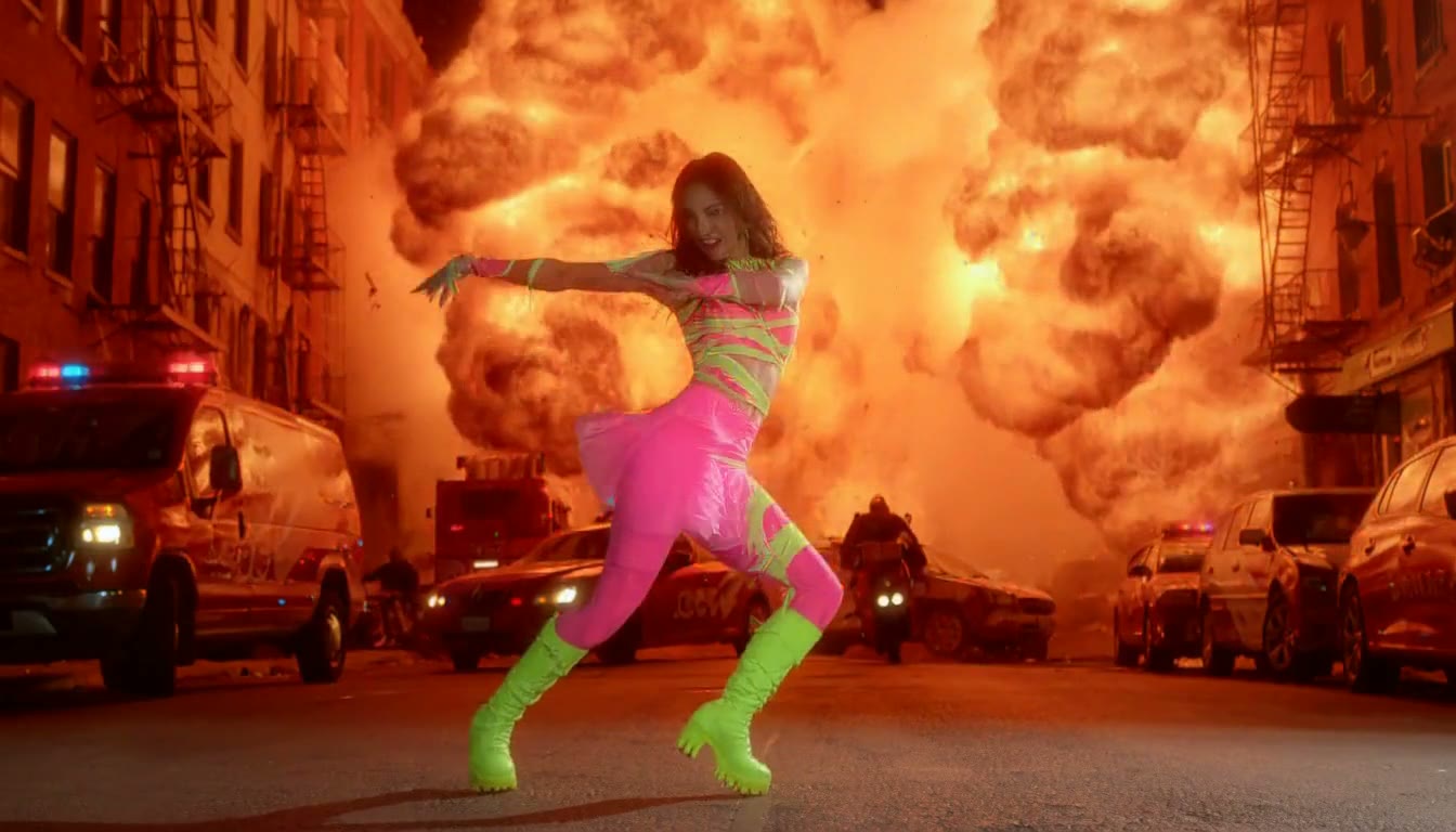 MiniMax H3 AI video example showing a person in a vibrant outfit is dancing amidst a chaotic urban explosion
