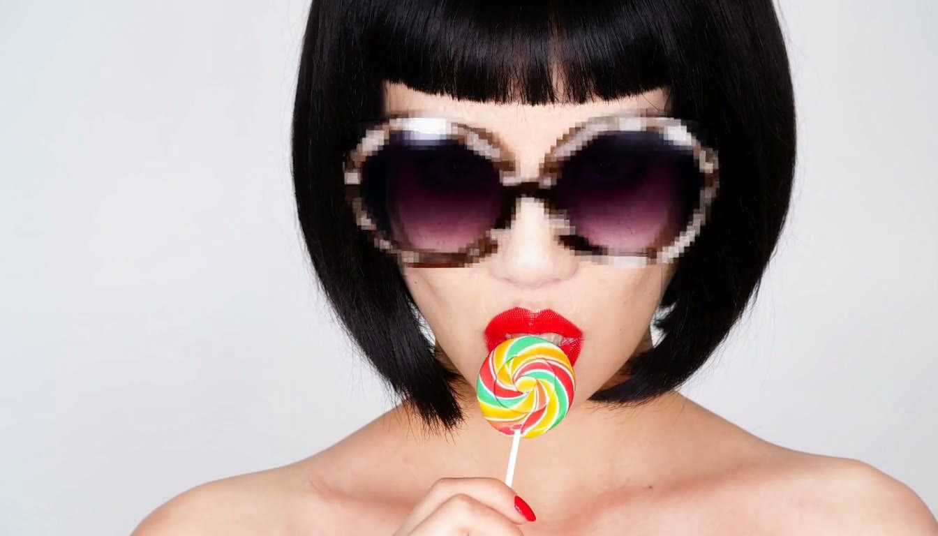 MiniMax H3 AI video example showing a person with a bob haircut and bold red lipstick holding a lollipop, wearing oversized sunglasses with a futuristic, geometric overlay